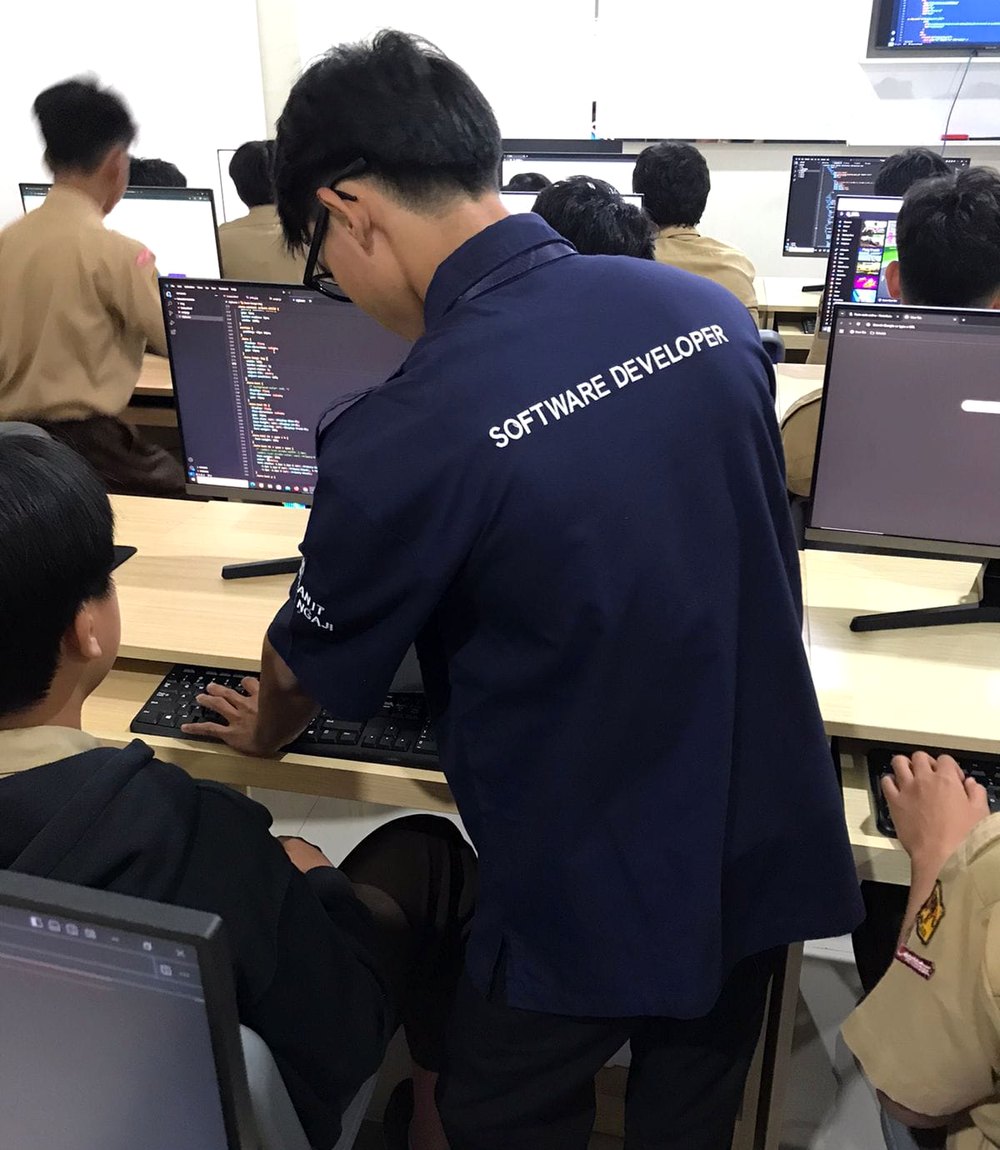 Mufti mentoring students in a coding class